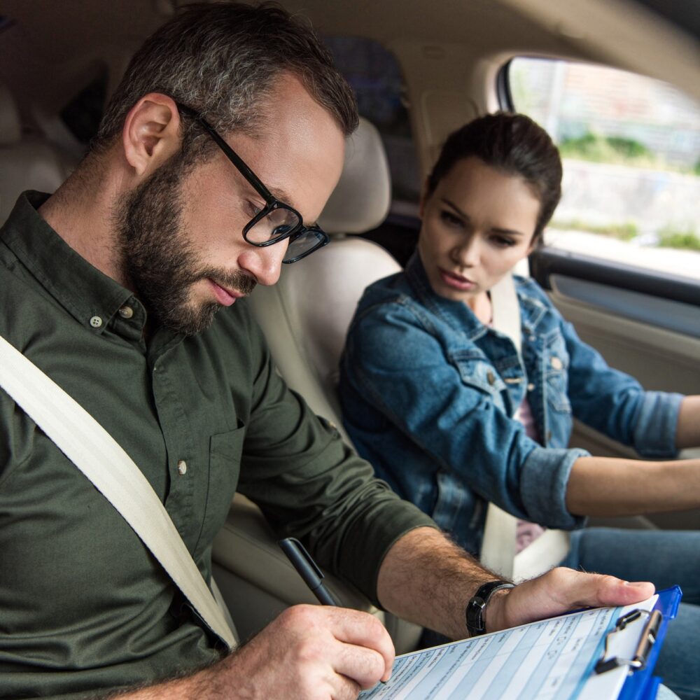 teacher-writing-something-to-clipboard-during-driving-test.jpg